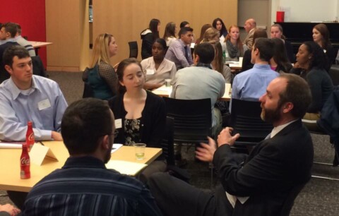 Lawyer-alum speaking with students in crowded room